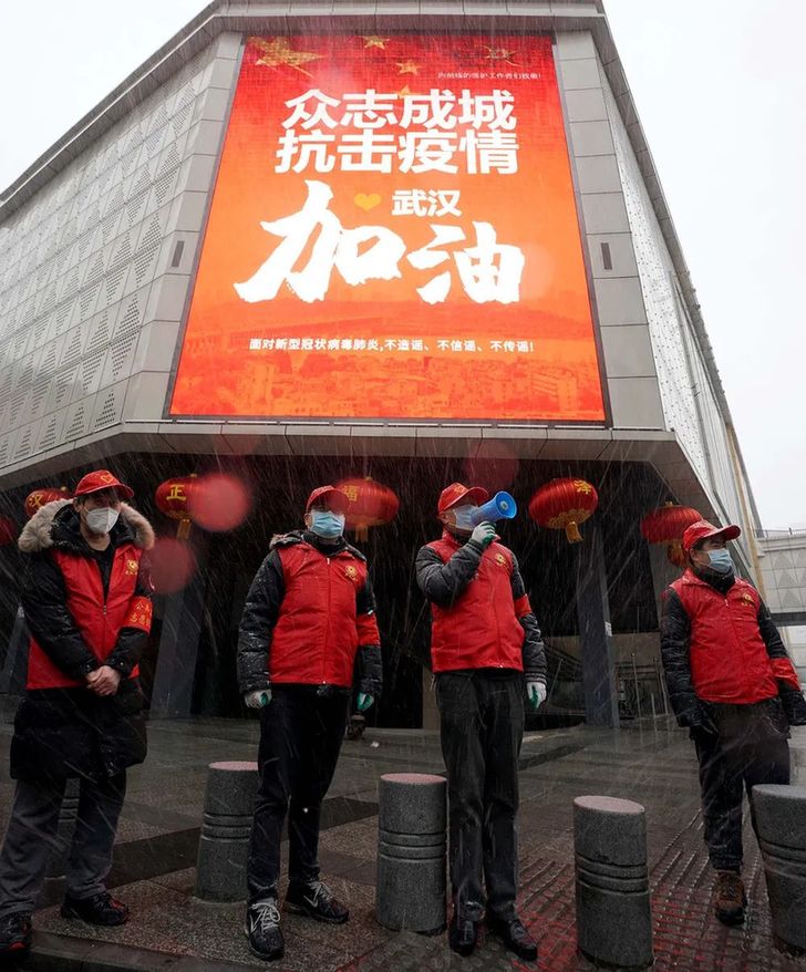 ↑2月15日，武汉市汉正街永宁社区的工作人员冒着风雪在街头进行防疫宣传。